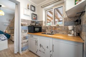 a kitchen with a sink and a microwave at Artemis Boutique House in Artemida