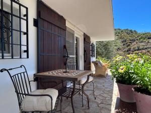 a porch with a table and chairs on a patio at Finca RustiQ in Torrox