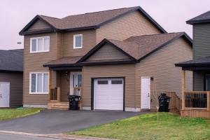 a brown house with a white garage at Modern Private 2-Bedroom Styld, Spacious & Comfy-Modern New 2-Bedroom Stylish, Spacious, Comfy & Nicely Furnished - Full Privacy in St. John's