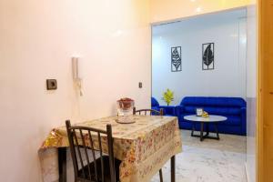 a dining room with a table and a blue couch at RiadRiad Bollywood-Dream Stay B in Benguerir