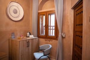 a chair sitting in a room with a window at بيت المقصرة Almuqasrah house in Nizwa +18 photos