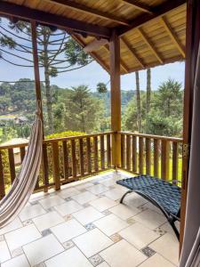 a porch with a hammock and a view at Estalagem Mandeville in Monte Verde
