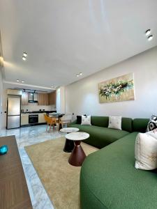 a living room with a green couch and a kitchen at Arena Maarif 41 in Maarif