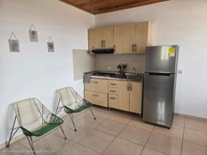 a kitchen with a stainless steel refrigerator and two chairs at Luxury flandes in Flandes