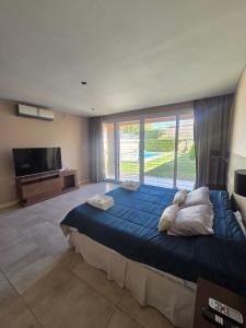 a bedroom with a large bed and a large window at Espectacular Casa con pileta y jacuzzi in San Juan +36 photos