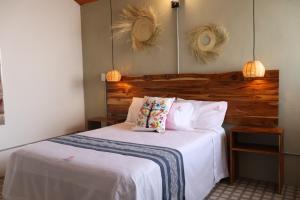 a bedroom with a bed with white sheets and two pillows at Hotel Ladrillo in Oaxaca City +3 photos