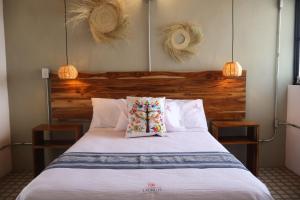 a bedroom with a large bed with two lamps on it at Hotel Ladrillo in Oaxaca City