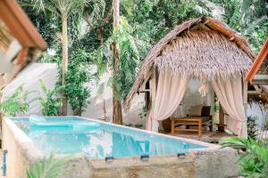 a resort with a swimming pool and a hut at Alaya Panglao in Panglao Island