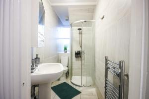 a white bathroom with a sink and a shower at 8ight Havens - Channel Euro Tunnel - Folkestone in Folkestone +257 photos