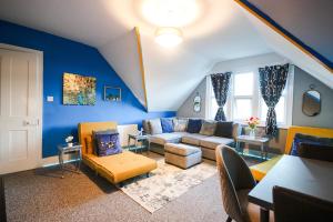 a living room with blue walls and a couch at 8ight Havens - Channel Euro Tunnel - Folkestone in Folkestone