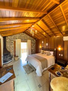 a large bedroom with a bed and a fireplace at Estalagem Mandeville in Monte Verde +24 photos