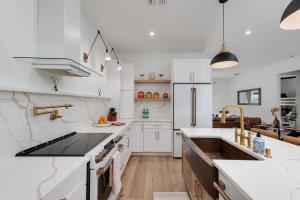 a white kitchen with a sink and a stove top oven at Spacious home private pool patio & bbq in Vero Beach