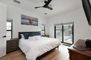a bedroom with a bed and a ceiling fan at Spacious home private pool patio & bbq in Vero Beach