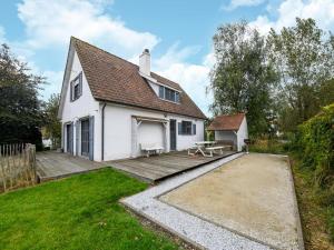 a white house with a picnic table in the yard at Floribert in Nieuwpoort-Bad