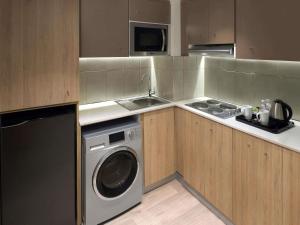 a small kitchen with a washing machine and a sink at Adagio Jeddah City Center in Jeddah
