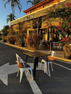 a table and two chairs in front of a restaurant at Bee Farm Off-Grid Tiny Home Stay in Tamaree