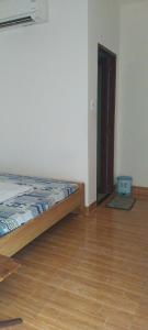 a bedroom with a bed and a wooden floor at Quyenhomestay in Cù Lao Tâu