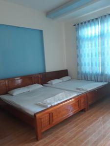 a bedroom with two beds and a window at Quyenhomestay in Cù Lao Tâu