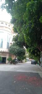 a street with a tree and a building and a car at Quyenhomestay in Cù Lao Tâu