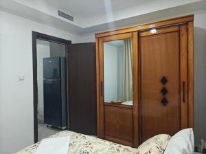 a bedroom with a wooden cabinet next to a bed at Résidence nid d'abeille Béjaïa in Bejaïa