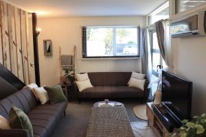 a living room with a couch and a tv at Central Nelson Townhouse in Nelson