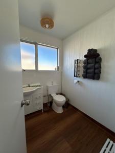 a white bathroom with a toilet and a sink at Central Nelson Townhouse in Nelson +41 photos