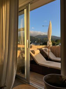 a balcony with white furniture and a view of the mountains at Central Nelson Townhouse in Nelson