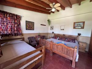 a bedroom with two beds and a ceiling fan at Hotel posada el paraíso in Tepoztlán