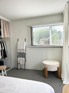 a bedroom with a bed and a window and a chair at Central Nelson Townhouse in Nelson