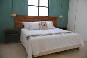 a bedroom with a large bed with white sheets and a window at Habitación arroqueño in Oaxaca City