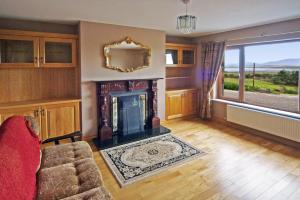 a living room with a fireplace and a large window at 4 Bed in Inch oc-i190 in Anascaul