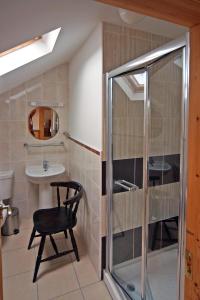 a bathroom with a chair and a sink and a shower at 4 Bed in Inch oc-i190 in Anascaul +17 photos
