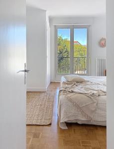 a bedroom with a bed and a large window at Socoa vue mer in Ciboure
