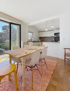a kitchen and dining room with a wooden table and chairs at Socoa vue mer in Ciboure +2 photos
