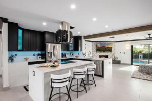 a kitchen with black and white cabinets and bar stools at Modern Roose-Private Pool-In Old Town Scottsdale in Scottsdale