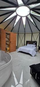 a room with a tub and a bed in a tent at Quinta La Primavera Ecolodge in Isnos