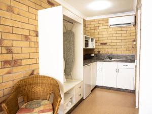 a kitchen with white cabinets and a brick wall at Farview Tavern in Farleigh