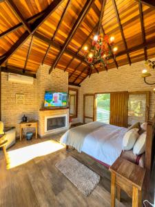 a bedroom with a bed and a tv in a room at Estalagem Mandeville in Monte Verde