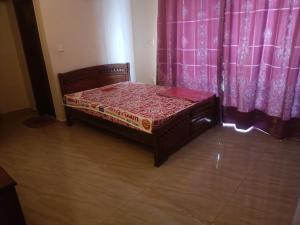 a small bed in a room with purple curtains at Call it a home in Rawalpindi