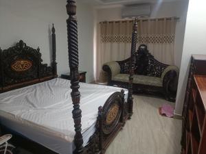 a bedroom with an ornate bed and two chairs at Call it a home in Rawalpindi