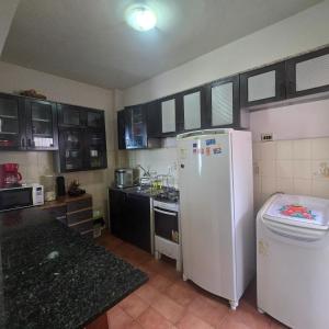 a kitchen with a white refrigerator and a sink at Apto 1,5 km do Shop. Manauara in Manaus