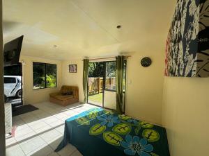 a bedroom with a bed with a blue bedspread on it at Mama Cat's Accommodation in Avarua