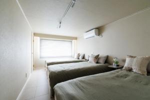 a room with three beds and a window at kobito in Toyama