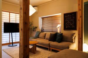 a living room with a couch and a television at kobito in Toyama