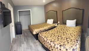 a hotel room with two beds and a flat screen tv at Motel 66 Los Angeles in Los Angeles