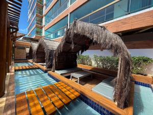 a swimming pool with a umbrella and avisor at Villas de Samoa - House with 4 bedrooms in Cabedelo