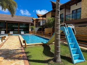 a swimming pool with a blue slide next to a house at Villas de Samoa - House with 4 bedrooms in Cabedelo +26 photos