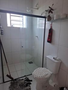 a bathroom with a shower and a toilet at Casa aconchegante in Peruíbe