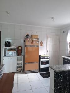 a kitchen with an old refrigerator and a stove at Casa aconchegante in Peruíbe +4 photos