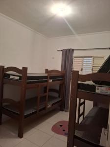 a room with two bunk beds and a ceiling at Casa aconchegante in Peruíbe